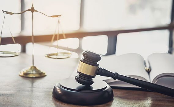 Judge’s gavel and brass scales of justice on a desk